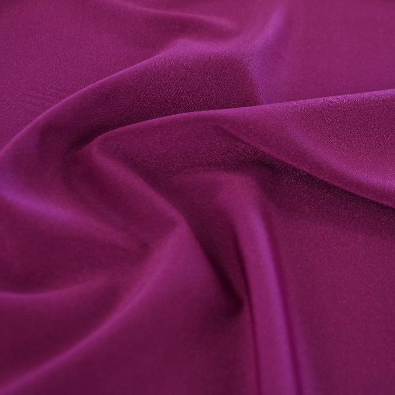 A swirled sample of Charisma shiny nylon spandex in the color magenta.