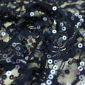 A swirled sample of charlize stretch lace sequin in the color navy.