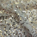 A swirled sample of charlize stretch lace sequin in the color platinum-silver.