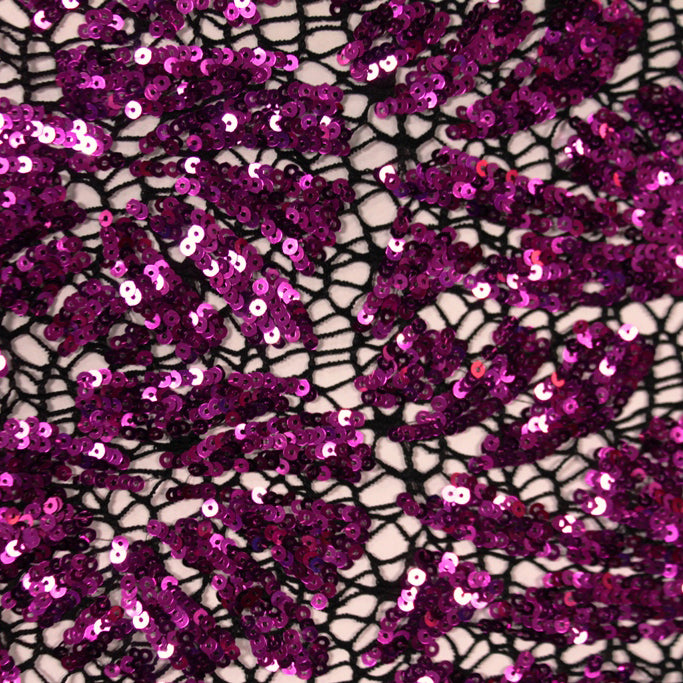 A flat sample of cluster lace sequin in the color black-fuchsia.