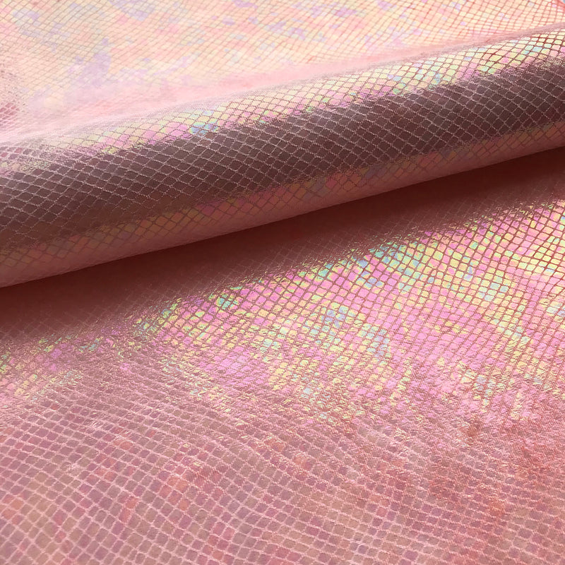 A folded sample of cobra foil printed stretch velvet in the color coral.