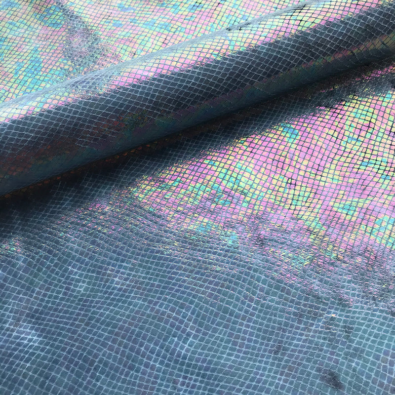 A folded sample of cobra foil printed stretch velvet in the color dim blue.