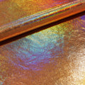A folded sample of cobra foil printed stretch velvet in the color gold.