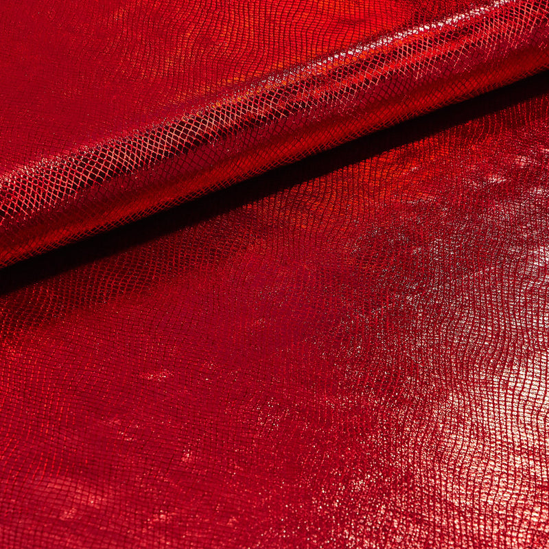 A folded sample of cobra foil printed stretch velvet in the color red.