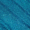 A panel of Cosmic GLOW spandex sequin in turquoise available at Blue Moon Fabrics.