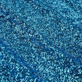 A flat sample of cosmic spandex sequin in the color turquoise available at blue moon fabrics.