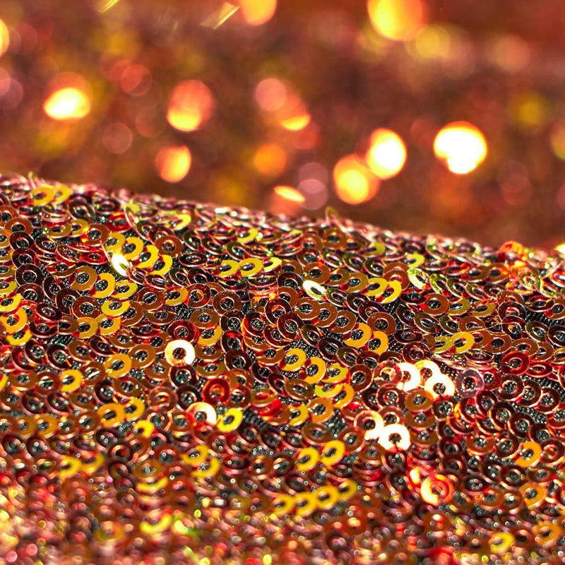 A folded sample of cosmic x spandex sequin in the color red available at blue moon fabrics.