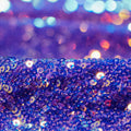 A folded sample of cosmic x spandex sequin in the color purple available at blue moon fabrics.