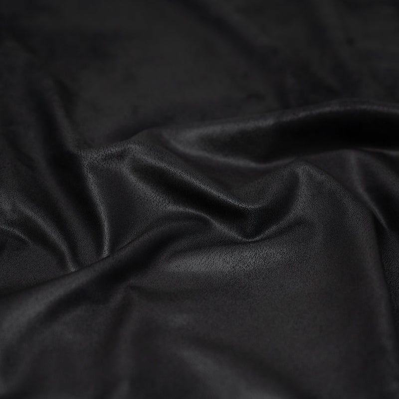 A crumpled piece of Cowboy Faux Leather Foil Printed Spandex in the color Black