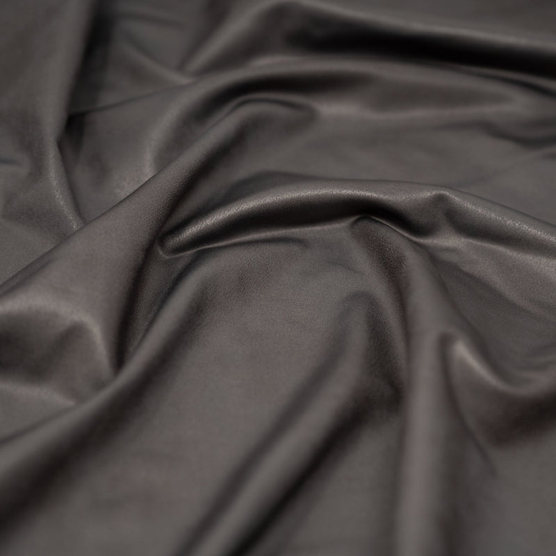A crumpled piece of Cowboy Faux Leather Foil Printed Spandex in the color Grey  