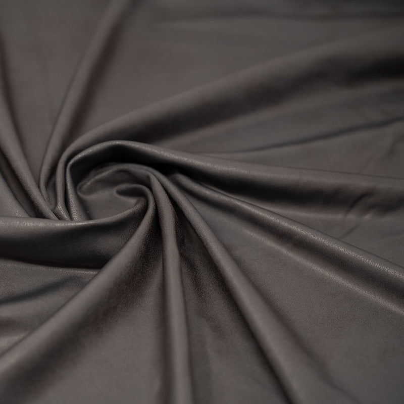 A swirled piece of Cowboy Faux Leather Foil Printed Spandex in the color Grey