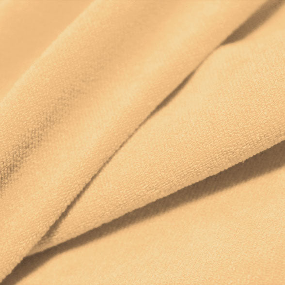 A folded piece of Cozy Polyester Spandex Terry Cloth in the color soft apricot