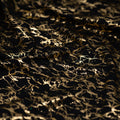 A crumpled piece of Cracked Foil Printed Microflex in the color Black/Gold