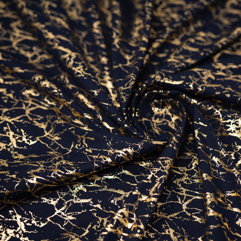 A swirled piece of Cracked Foil Printed Microflex in the color Navy-Gold