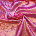 A swirled sample of d-isis foiled stretch velvet in the color pink.