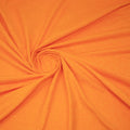 A swirled sample of EcoDelish Double Peached Melange recycled polyester spandex fabric in the color Mango.