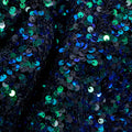 A flat sample of duchess stretch velvet sequin in the color black-blue-green.