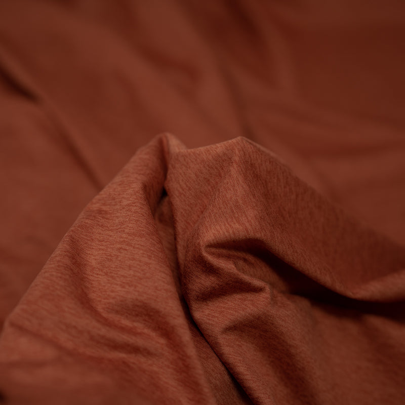 A detailed shot of EcoDelish Double Peached Melange recycled polyester spandex fabric in the color Terracotta..