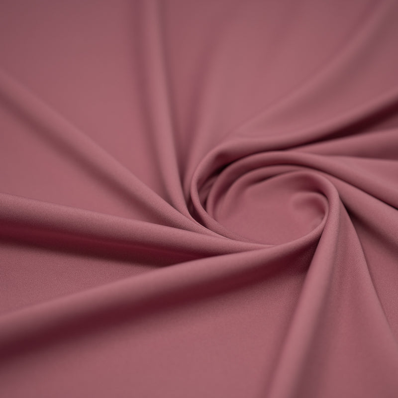 A swirled sample of EcoTechFlex recycled polyester spandex in the color Rosebud.