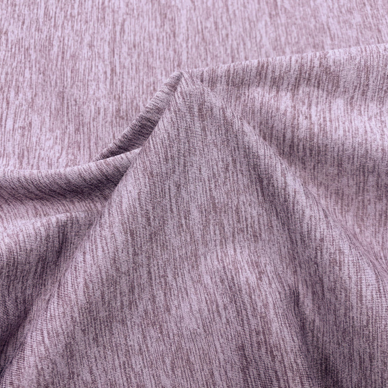 A swirled sample of ecodelish double peached heather recycled polyester spandex fabric in the color lilac.