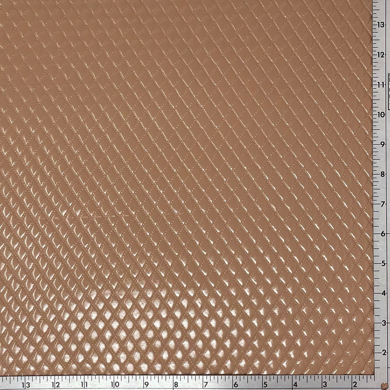 A sample of quilted hipster polyurethane coated spandex in the color almond with a ruler for scale.