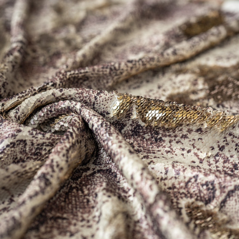A close up detail shot of a swirled sample of Golden Anaconda Printed Flip Sequin on Spandex. 