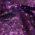 A swirled sample of flirt stretch mesh sequin in the color dark purple.