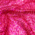 A swirled sample of flirt stretch mesh sequin in the color fuchsia.
