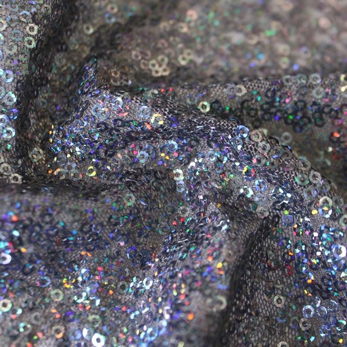 A swirled sample of flirt stretch mesh sequin in the color gunmetal.