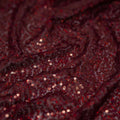 A swirled sample of flirt stretch mesh sequin in the color  wine/wine.