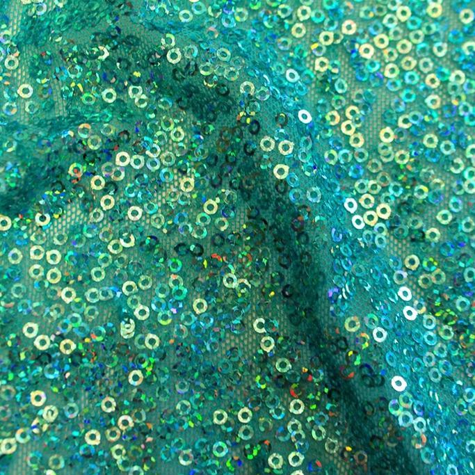A swirled sample of flirt stretch mesh sequin in the color turquoise.