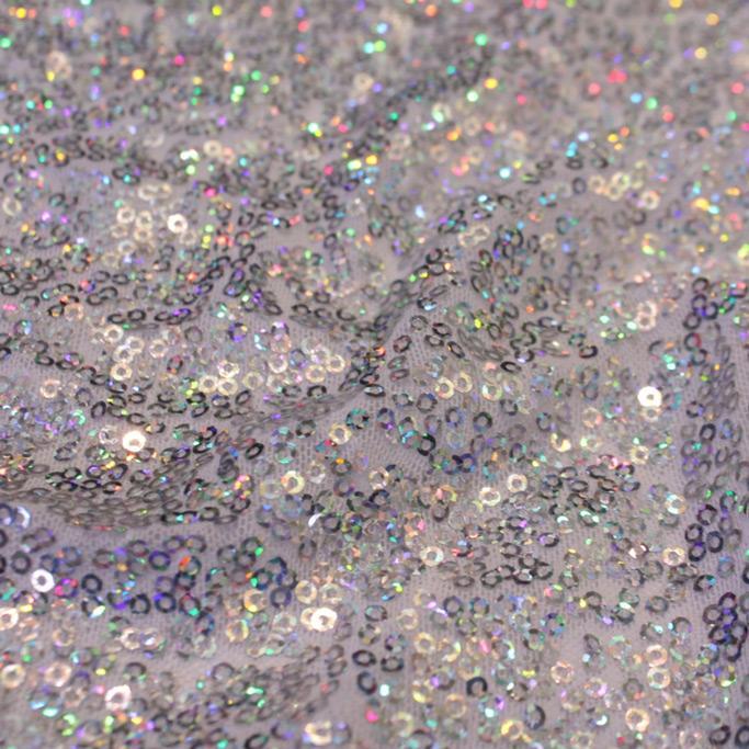 A swirled sample of flirt stretch mesh sequin in the color white silver.