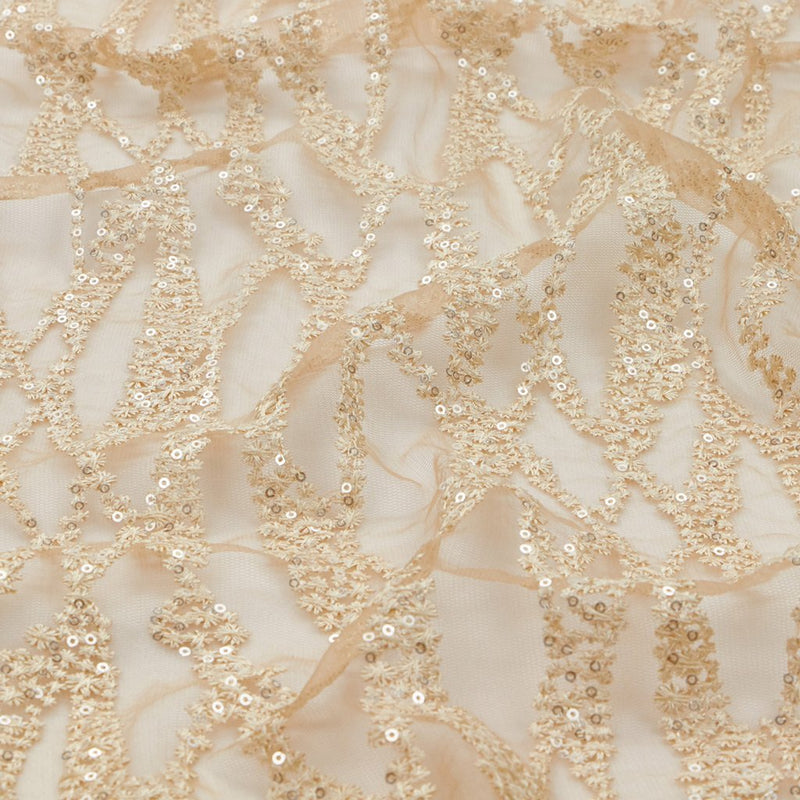 A flat sample of forget me not embroidered mesh in the color champagne.