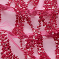 A flat sample of forget me not embroidered mesh in the color fuchsia.