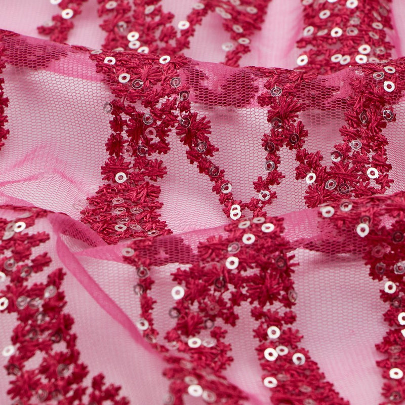 A flat sample of forget me not embroidered mesh in the color fuchsia.