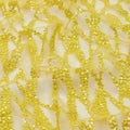 A flat sample of forget me not embroidered mesh in the color yellow.