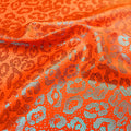 A swirled sample of fun leo foil printed spandex in the color orange.
