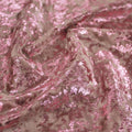 A swirled sample of gilded stretch velvet in the color rose pink-baby pink.