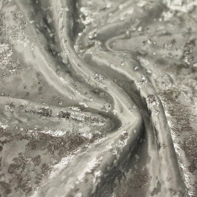 A swirled sample of gilded stretch velvet in the color silver.