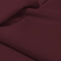 A flat sample of allure polyester spandex in the color fig.