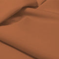 A flat sample of allure polyester spandex in the color terra cotta.
