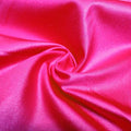 A swirled piece of nylon spandex fabric with an all over shiny look in the color fuchsia.