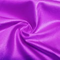 A swirled piece of nylon spandex fabric with an all over shiny look in the color rosebud.
