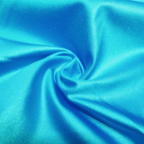 A swirled piece of nylon spandex fabric with an all over shiny look in the color turquoise.