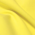 A flat sample of flexfilt recycled polyester spandex in the color low key lemon.