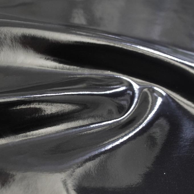 A swirled piece of polyurethane coated polyester spandex in the color black.