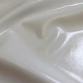 A  swirled piece of polyurethane coated polyester spandex in the color white.