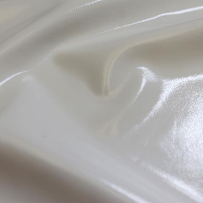 A  swirled piece of polyurethane coated polyester spandex in the color white.