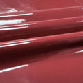 A swirled piece of polyurethane coated polyester spandex in the color Hipster Burgundy