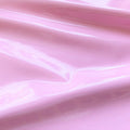 A swirled piece of polyurethane coated polyester spandex in the color light pink.